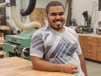 Liam leaning on a counter in the carpentry lab