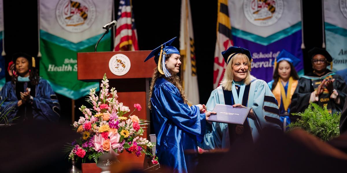 Katie Cortina receiving her diploma from Dr. Dawn Lindsay during the 2026 commencement ceremony.