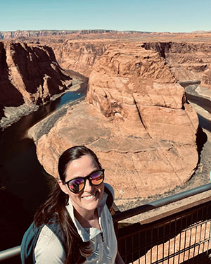 Kathleen Keough wearing sunglasses and standing in front of Horseshoe Bend