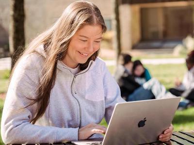 Student on computer outside